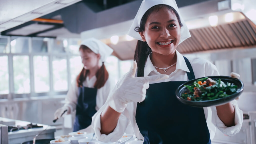 Group of schoolgirls having fun learning to cook. Female student